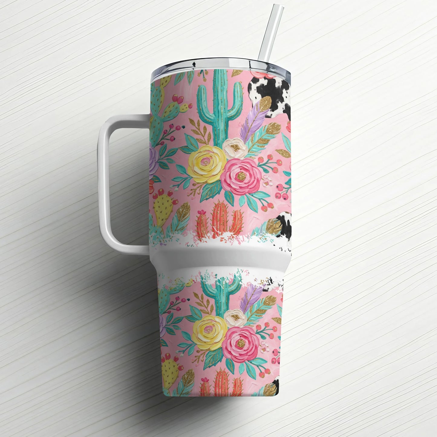 Pink floral and cactus tumbler with cow print lid and straw.