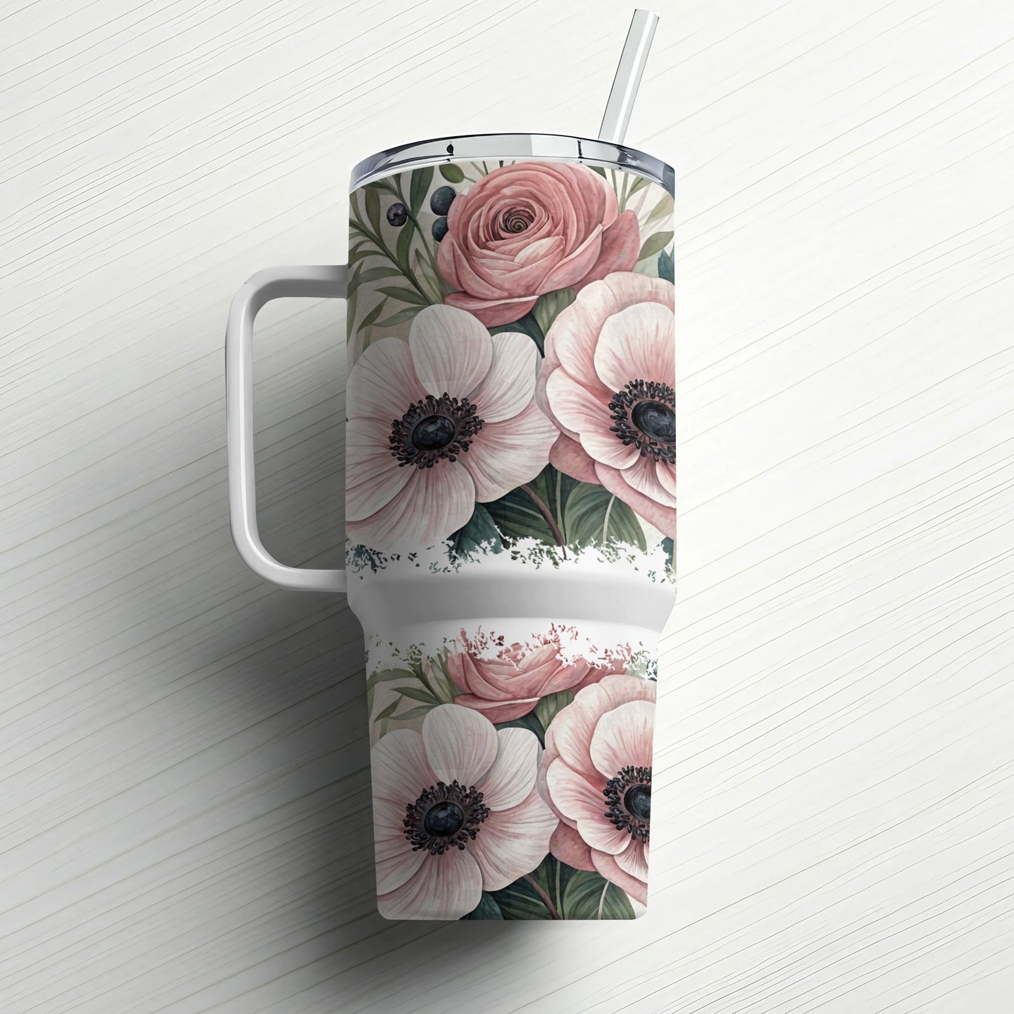 White tumbler with pink flowers and green leaves, white handle and straw.