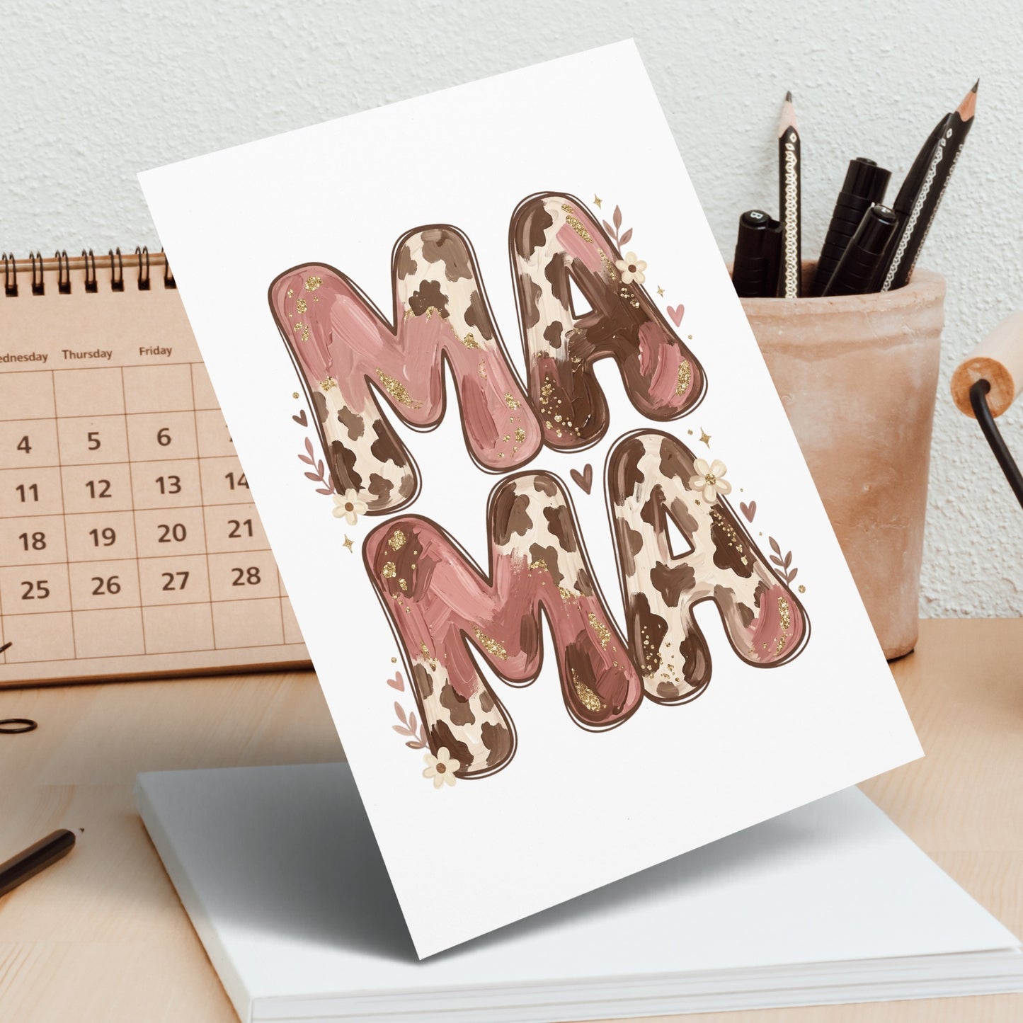 "Mama" text with cow print and floral accents on a card.
