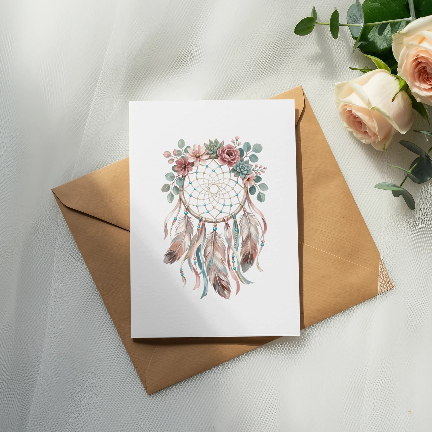 Dreamcatcher illustration with feathers and flowers on a card, atop an envelope.