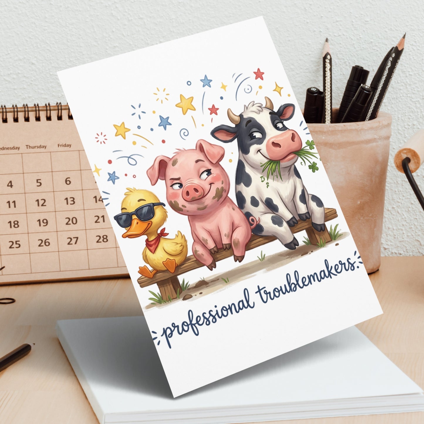 Greeting card featuring a pig, duck, and cow on a fence with "professional troublemakers" text.