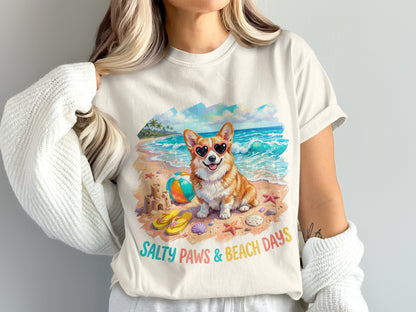 Corgi wearing heart sunglasses on a beach with "Salty Paws & Beach Days" text.