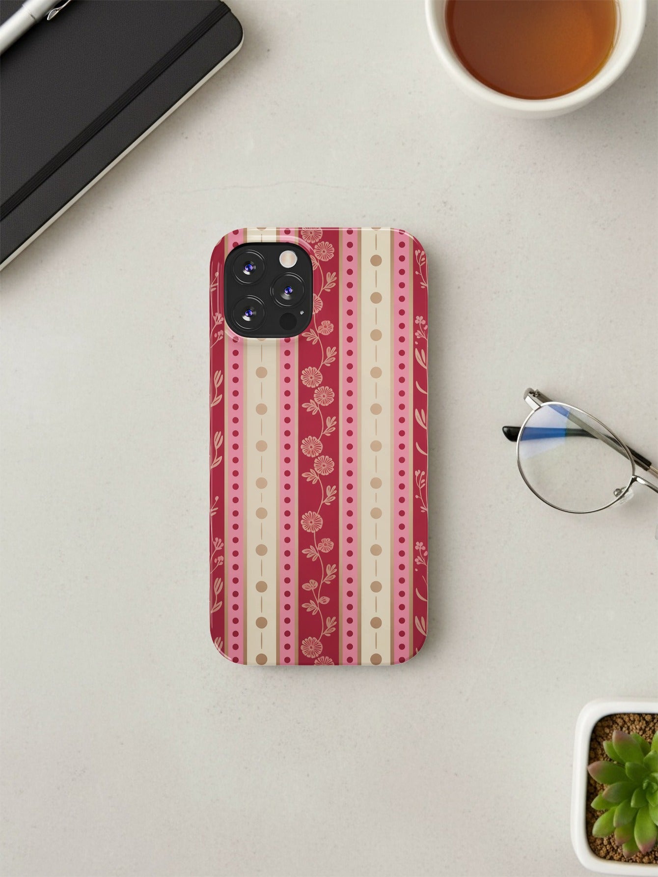 iPhone case with pink, beige, and red vertical stripes and floral accents.