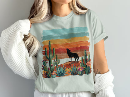 Silhouette of a wolf howling against a colorful desert sunset with cacti.