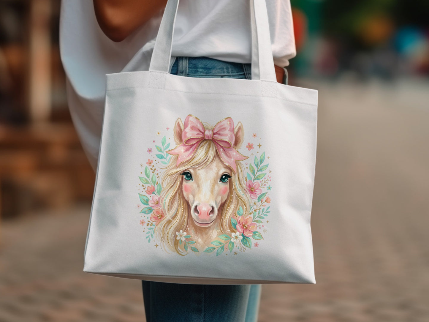 White tote bag with a whimsical horse illustration and pink bow.