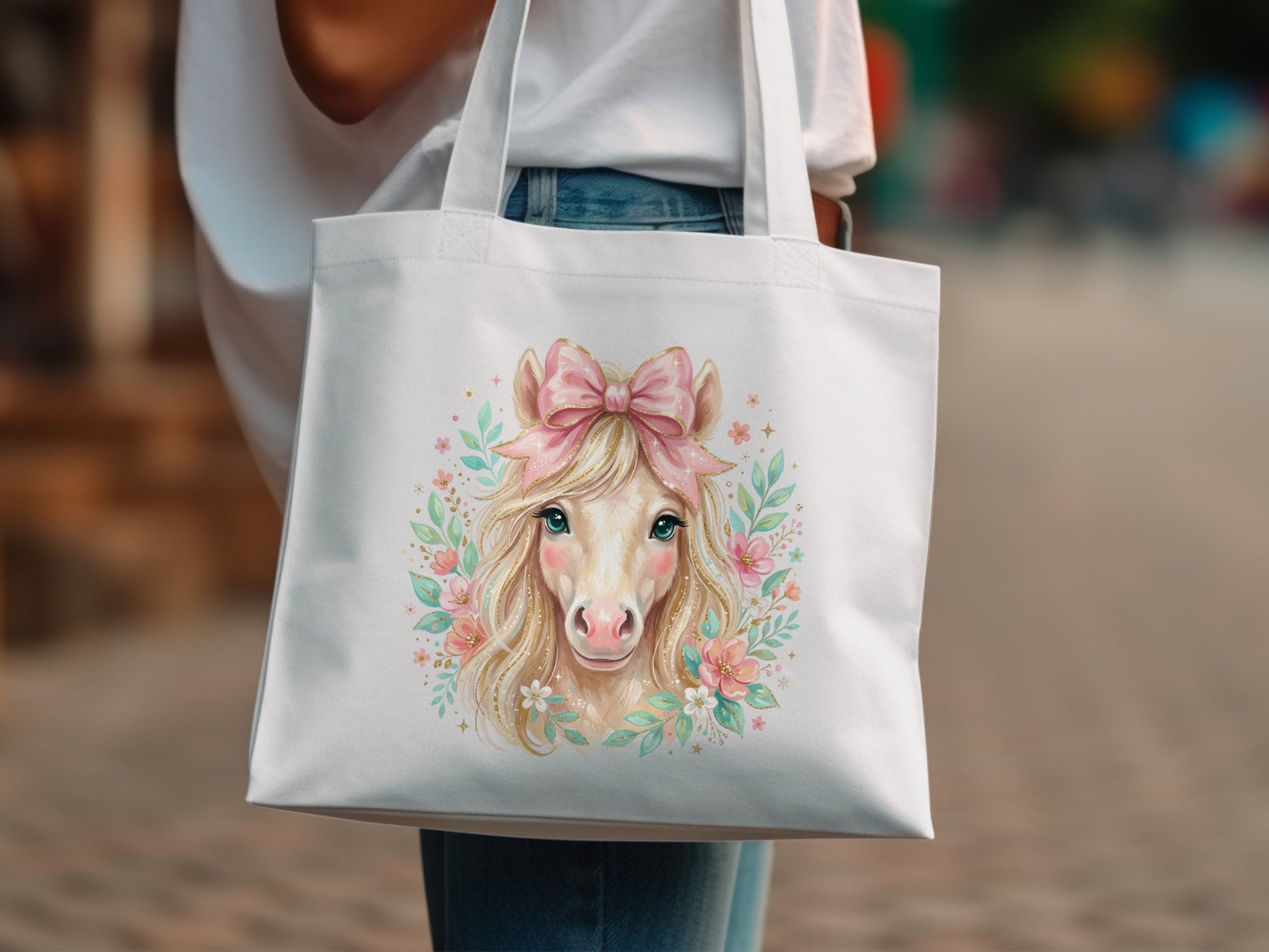 White tote bag with a whimsical horse illustration and pink bow.