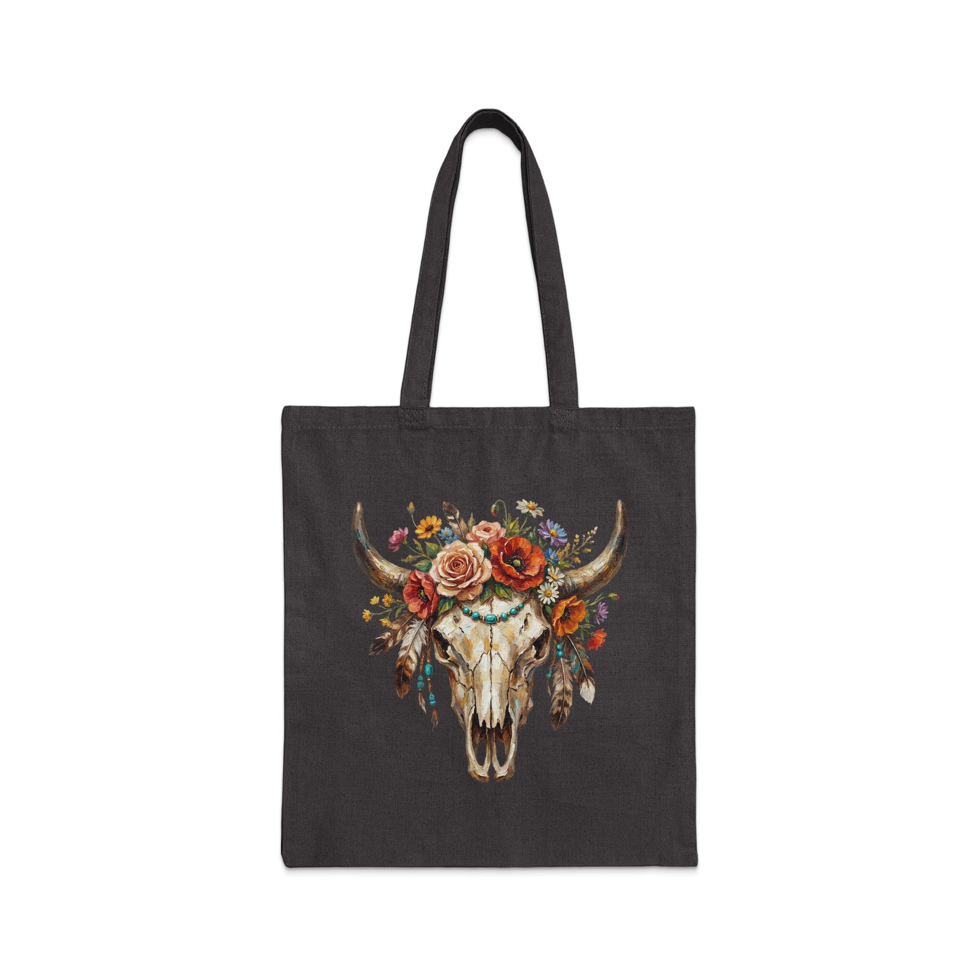 Dark tote bag with a watercolor painting of a bull skull adorned with flowers and feathers.