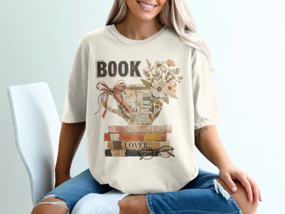 Cream t-shirt with "BOOK LOVER" text and teacup illustration on books.