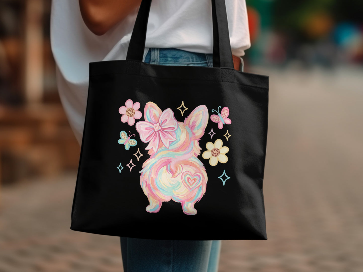 Black tote bag with pastel rainbow bunny butt and flowers.