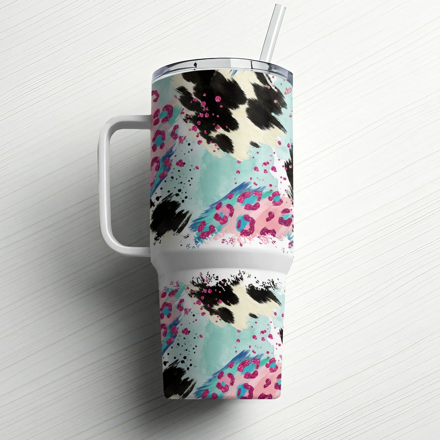 White tumbler with cow print and pink leopard pattern, straw included.