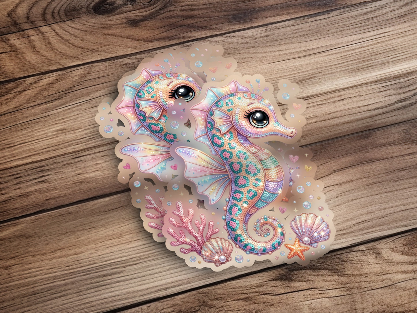 Two iridescent seahorses surrounded by seashells and starfish on a wooden background.