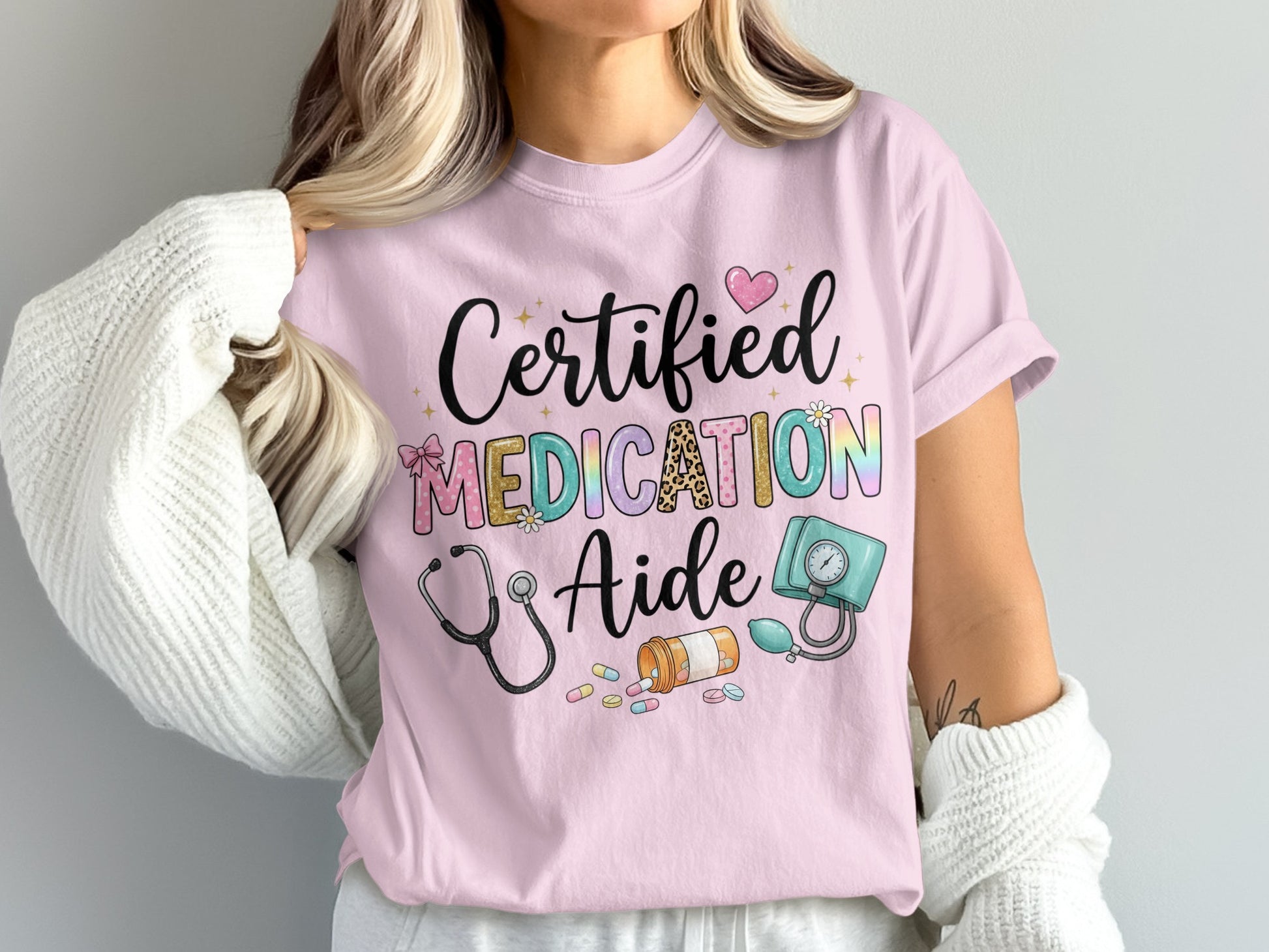 Pink t-shirt with "Certified Medication Aide" text and medical icons.