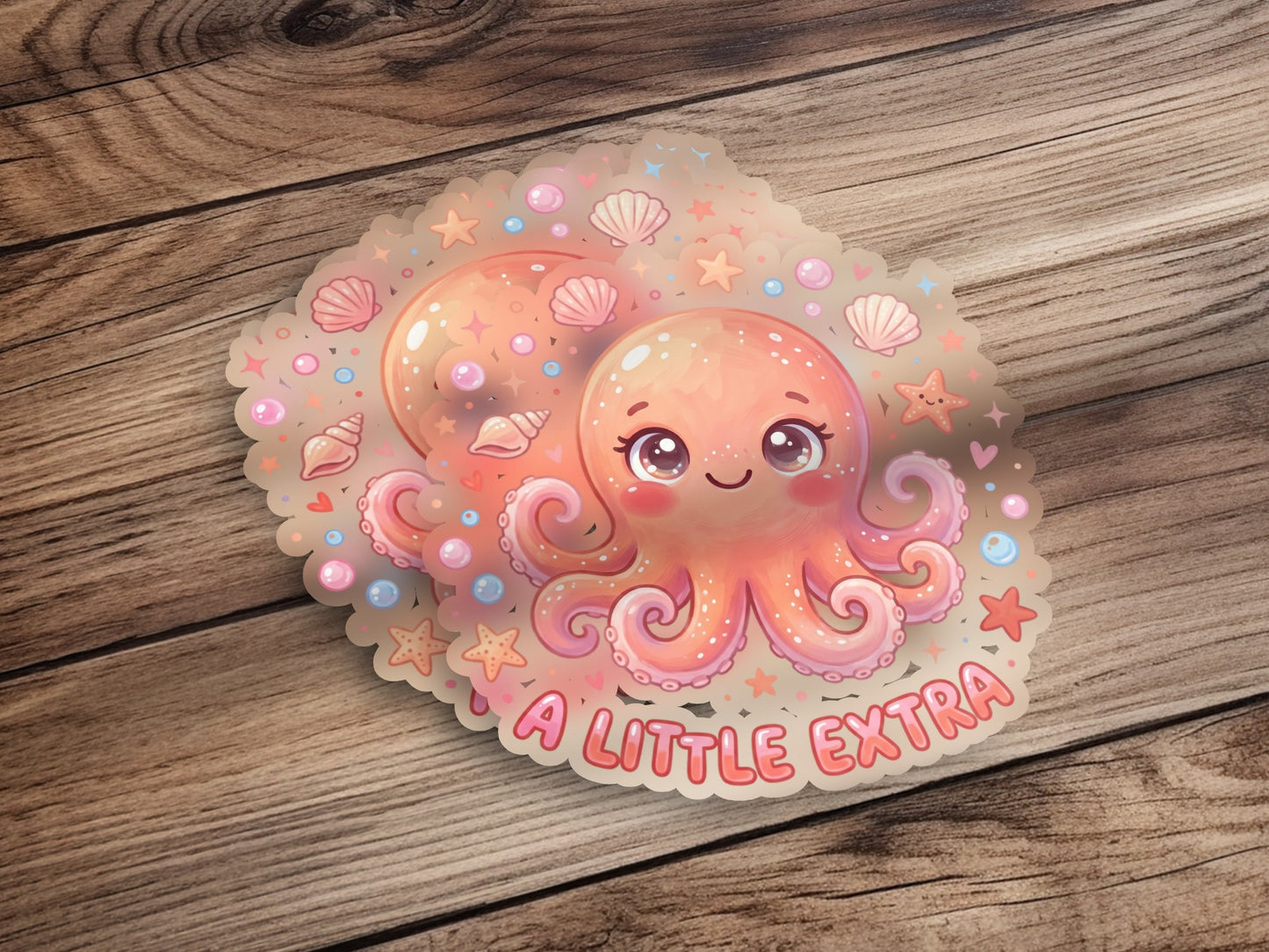 Kawaii octopus sticker with "A LITTLE EXTRA" text and seashells.