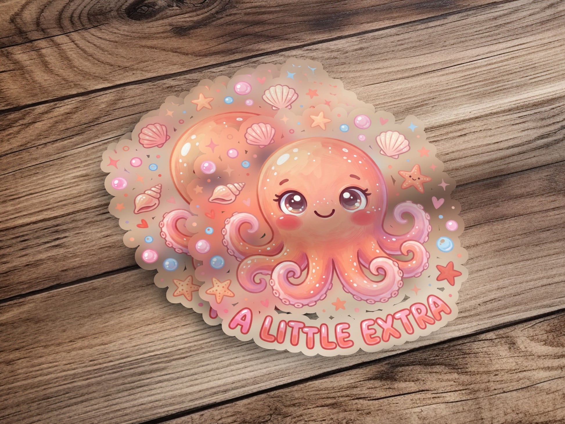 Kawaii octopus sticker with "A LITTLE EXTRA" text and seashells.