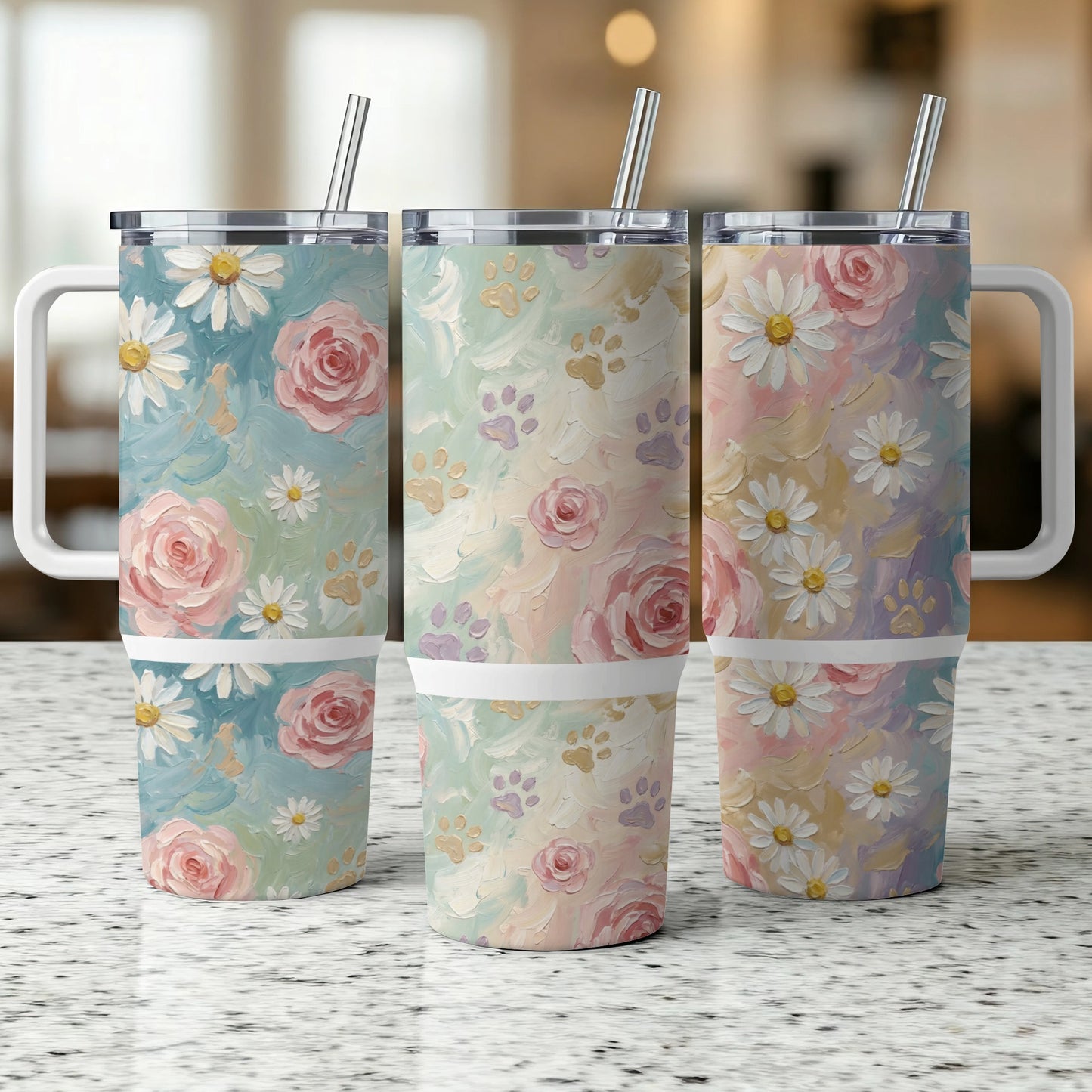 Three floral and paw print tumblers with handles and straws.