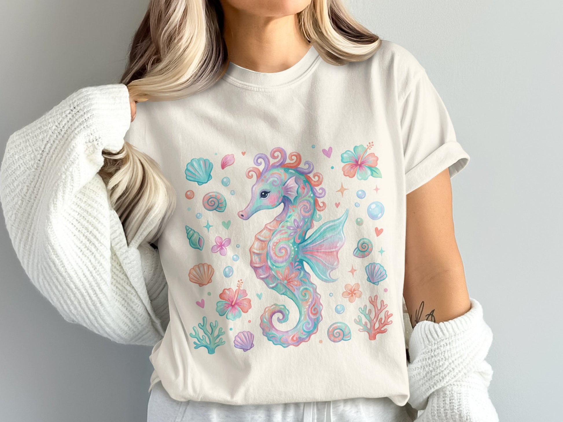 Watercolor seahorse with shells and flowers, on a cream t-shirt.