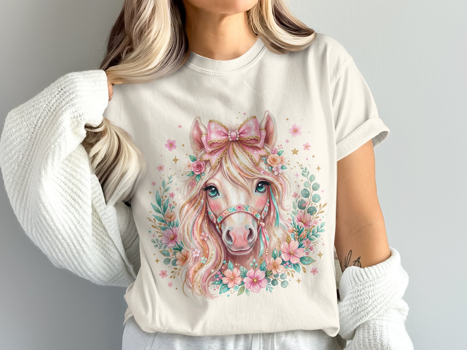Cream t-shirt with a watercolor horse graphic adorned with flowers and a bow.