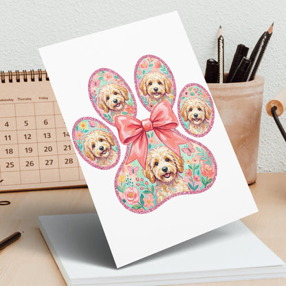 Greeting card featuring a paw print with multiple dog portraits and a pink bow.