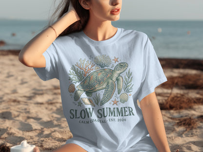 Light blue t-shirt with sea turtle, coral, and shell graphic; "Slow Summer" text.