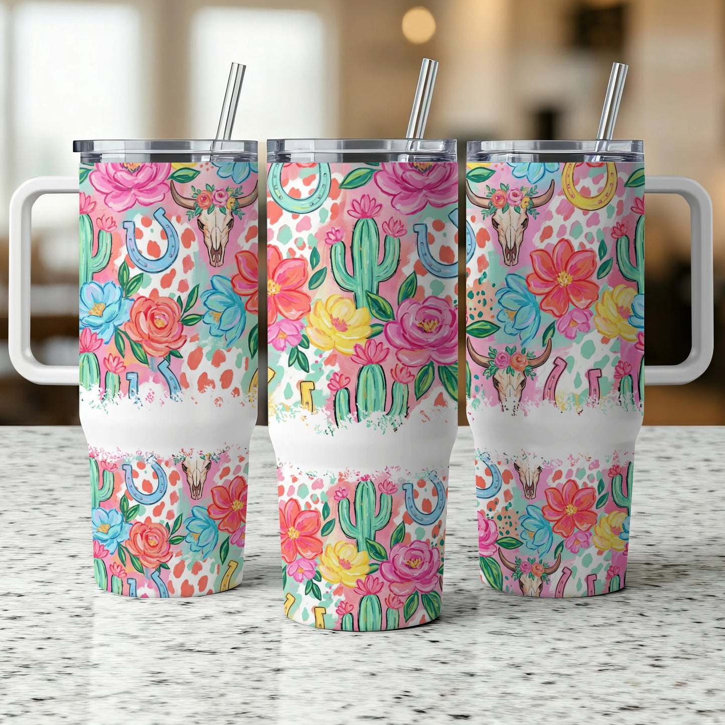 Three tumblers with floral, cactus, and horseshoe designs on a speckled countertop.