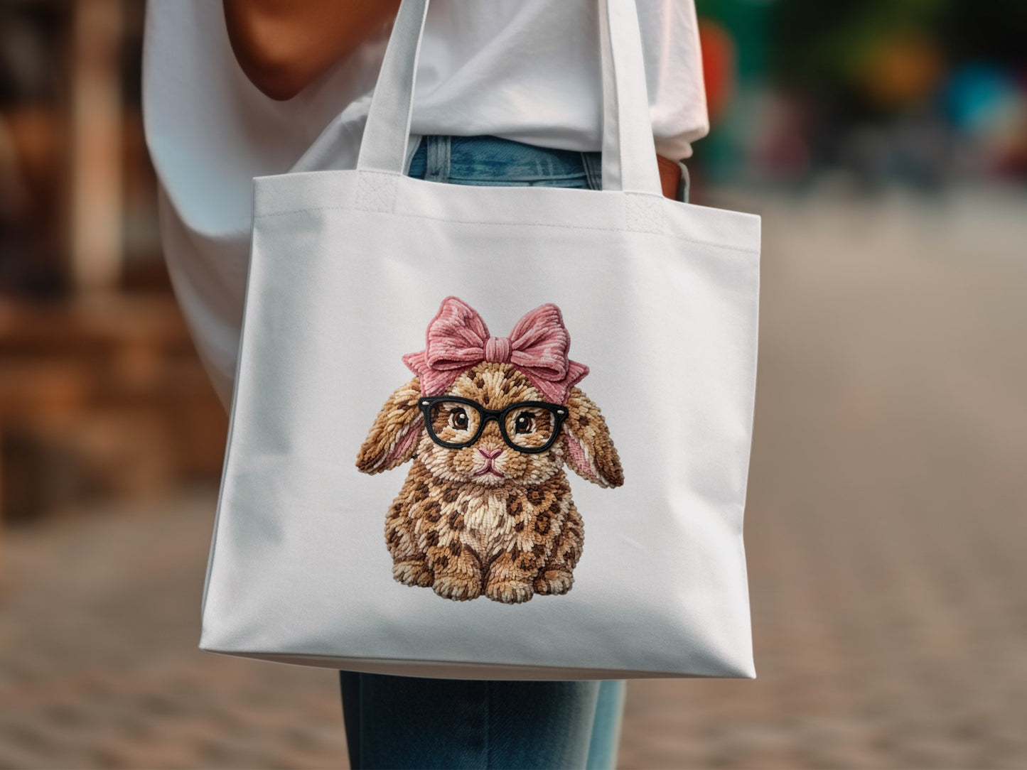 White tote bag with embroidered fluffy bunny wearing glasses and a pink bow.