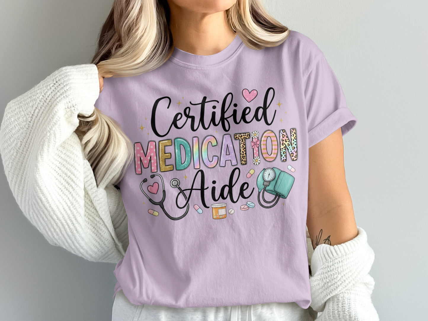 Lavender t-shirt with "Certified Medication Aide" text and medical icons.