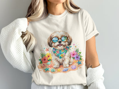 Shih Tzu wearing sunglasses and bandana sits on a beach with shells and flowers.