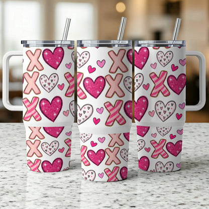 Three tumblers with pink XOXO and heart pattern on a countertop.