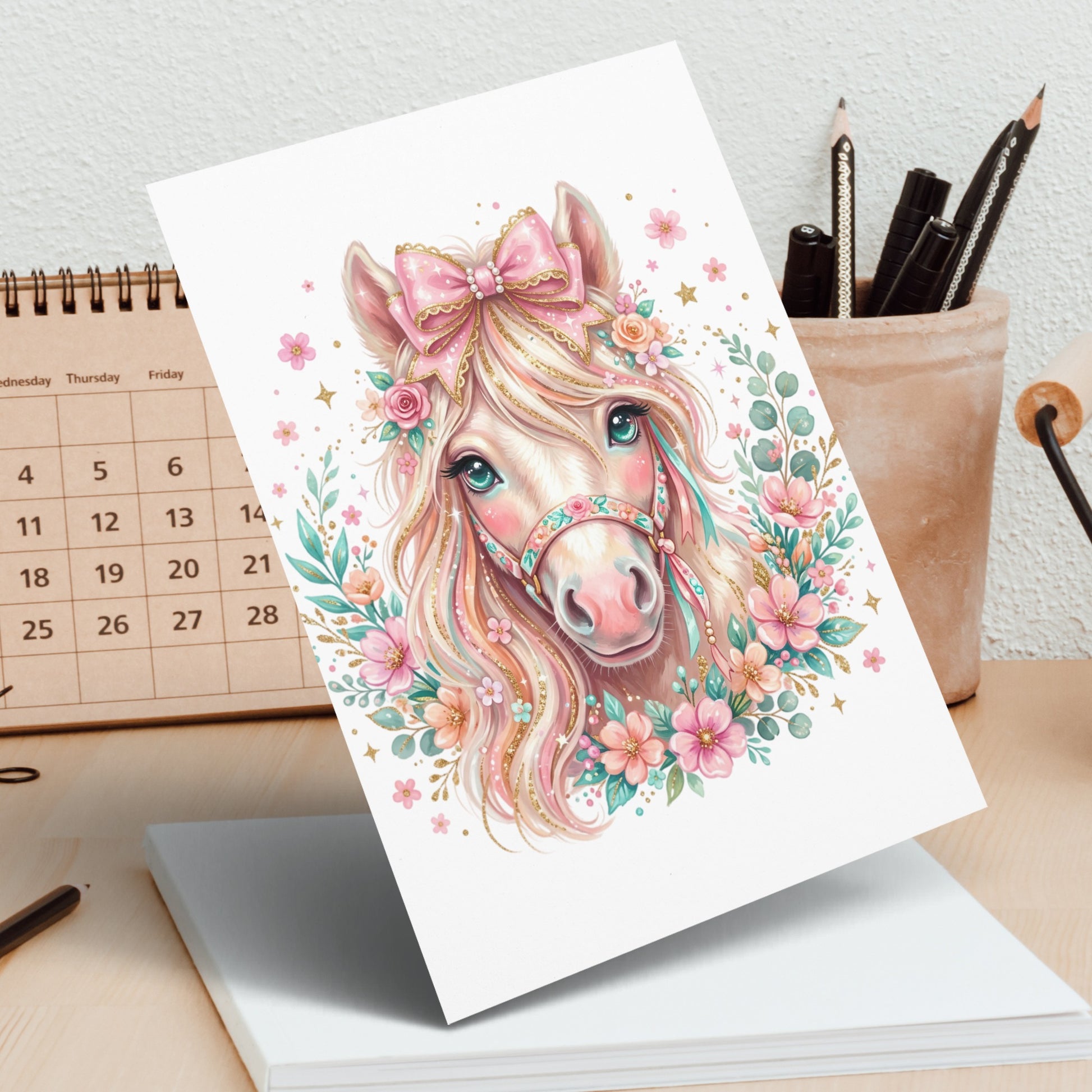 Pink unicorn with flowers and bow, with calendar in background.