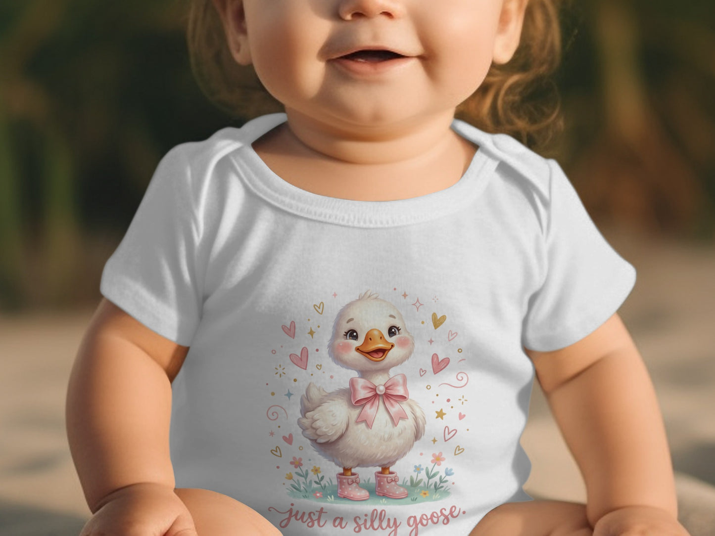 Baby in white bodysuit with cartoon duck wearing pink bow and boots.