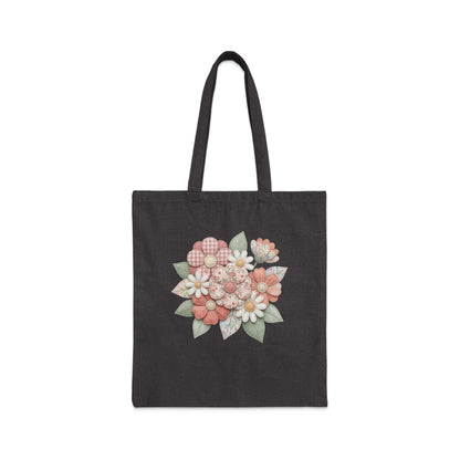 Dark tote bag with a floral appliqué featuring pink and white flowers.