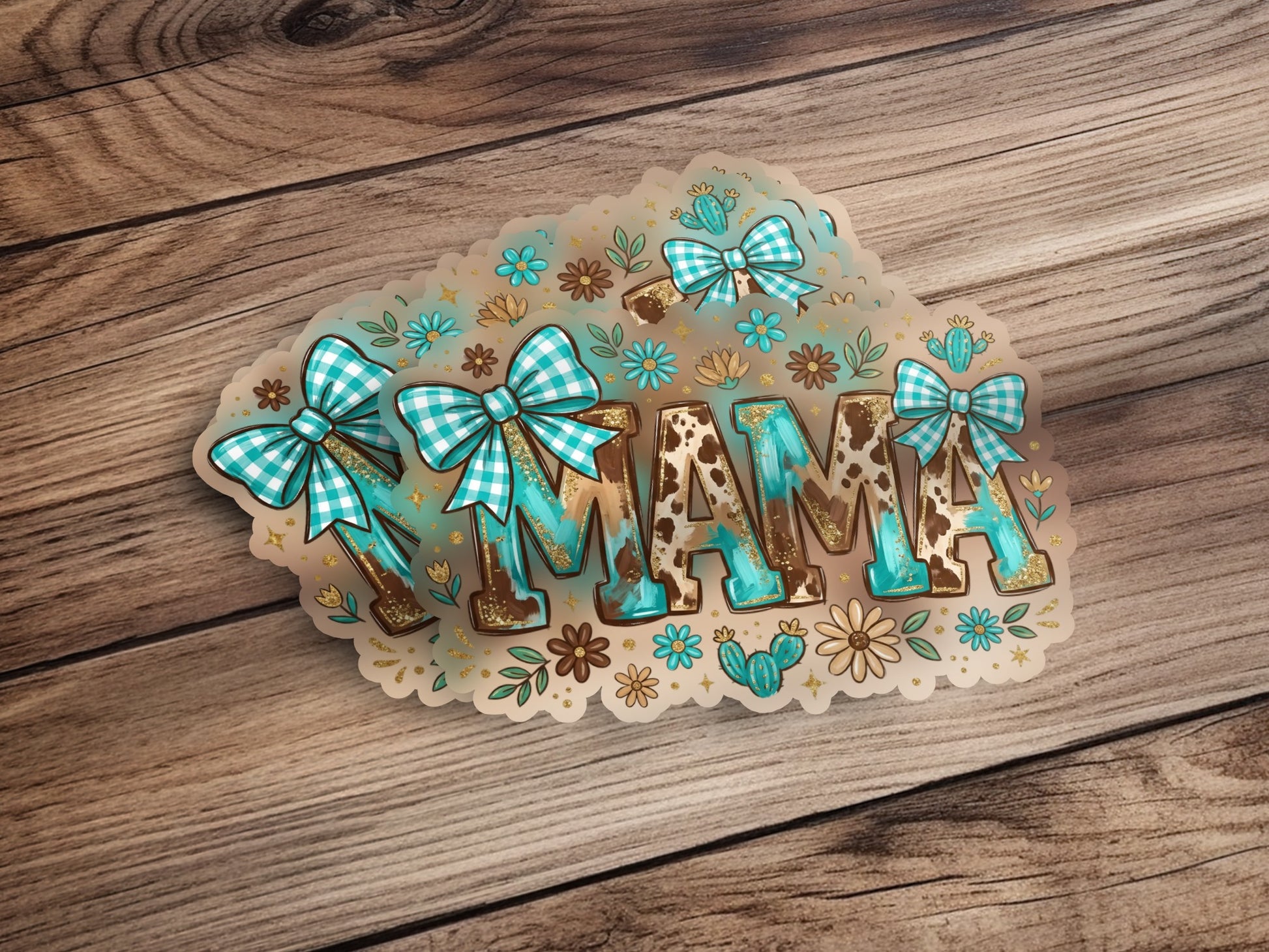 Turquoise "MAMA" lettering with cow print and floral accents, on a wood background.