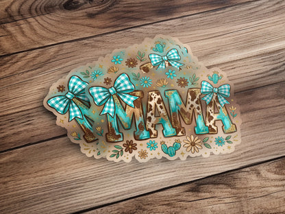Turquoise "MAMA" lettering with cow print and floral accents, on a wood background.