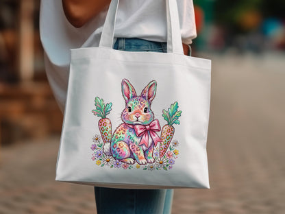 White tote bag with a rainbow bunny, carrots, and flowers design.