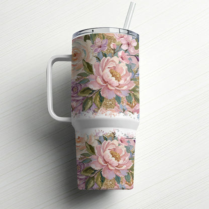 Floral patterned tumbler with handle and straw on a white wooden surface.