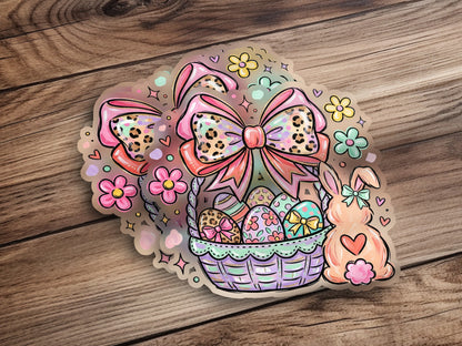 Easter basket with colorful eggs, a bunny, and bows on a wooden background.