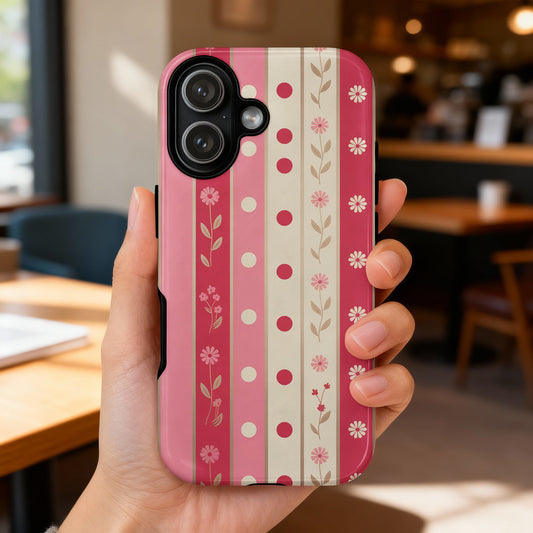 Pink striped phone case with floral pattern, held by a hand.
