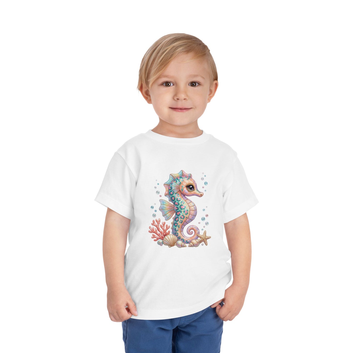 White t-shirt with cartoon seahorse, coral, and seashells illustration.
