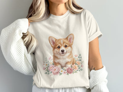 Cream t-shirt with a watercolor corgi illustration surrounded by pink flowers.