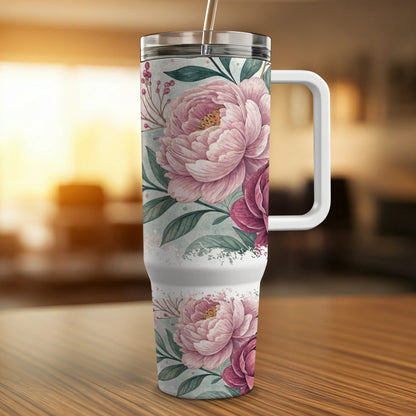 White tumbler with pink floral pattern and handle.