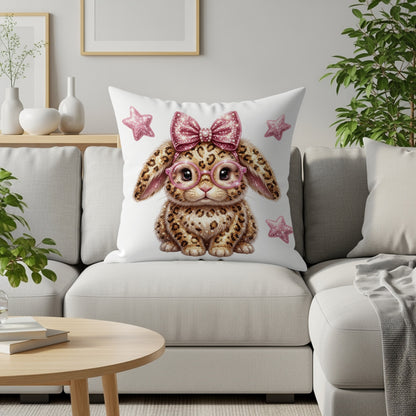 Leopard print bunny with pink glasses and bow on a couch.