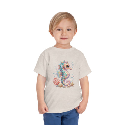 Child wearing a light gray t-shirt with a colorful seahorse and coral graphic.