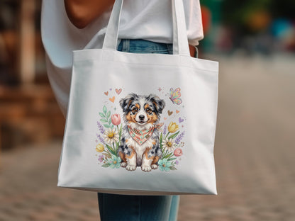 White tote bag with illustration of a puppy and butterflies surrounded by flowers.