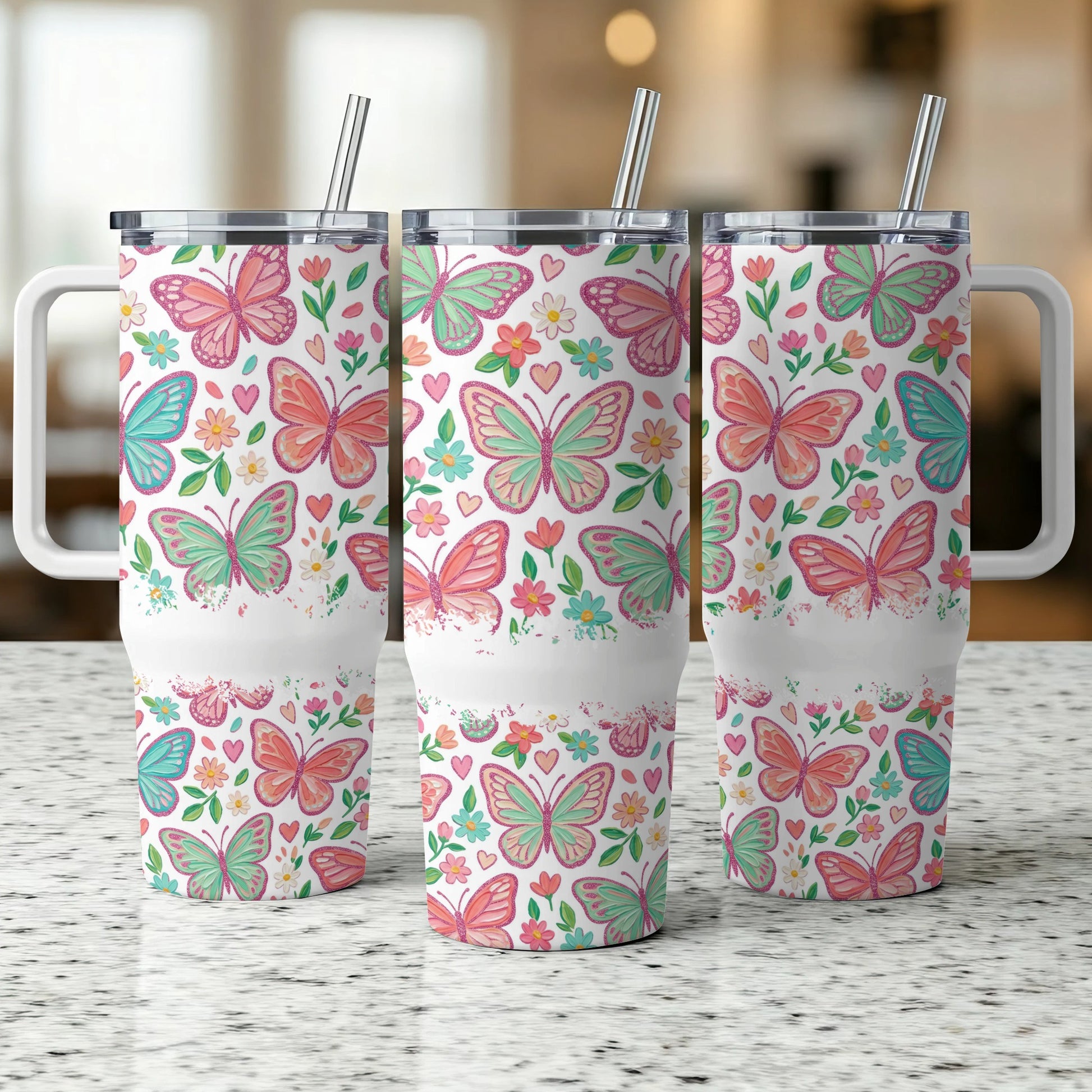 Three insulated tumblers with pink and green butterflies and floral patterns.