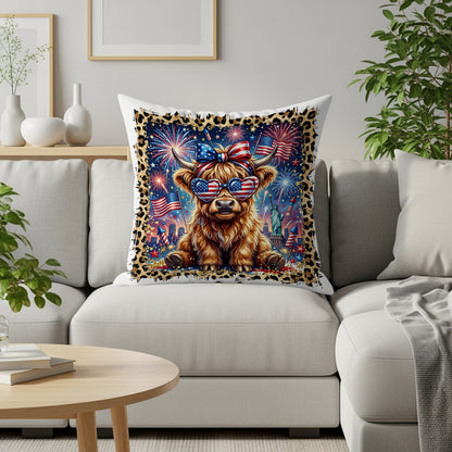 Highland cow wearing sunglasses and American flag bow, sitting on a couch.