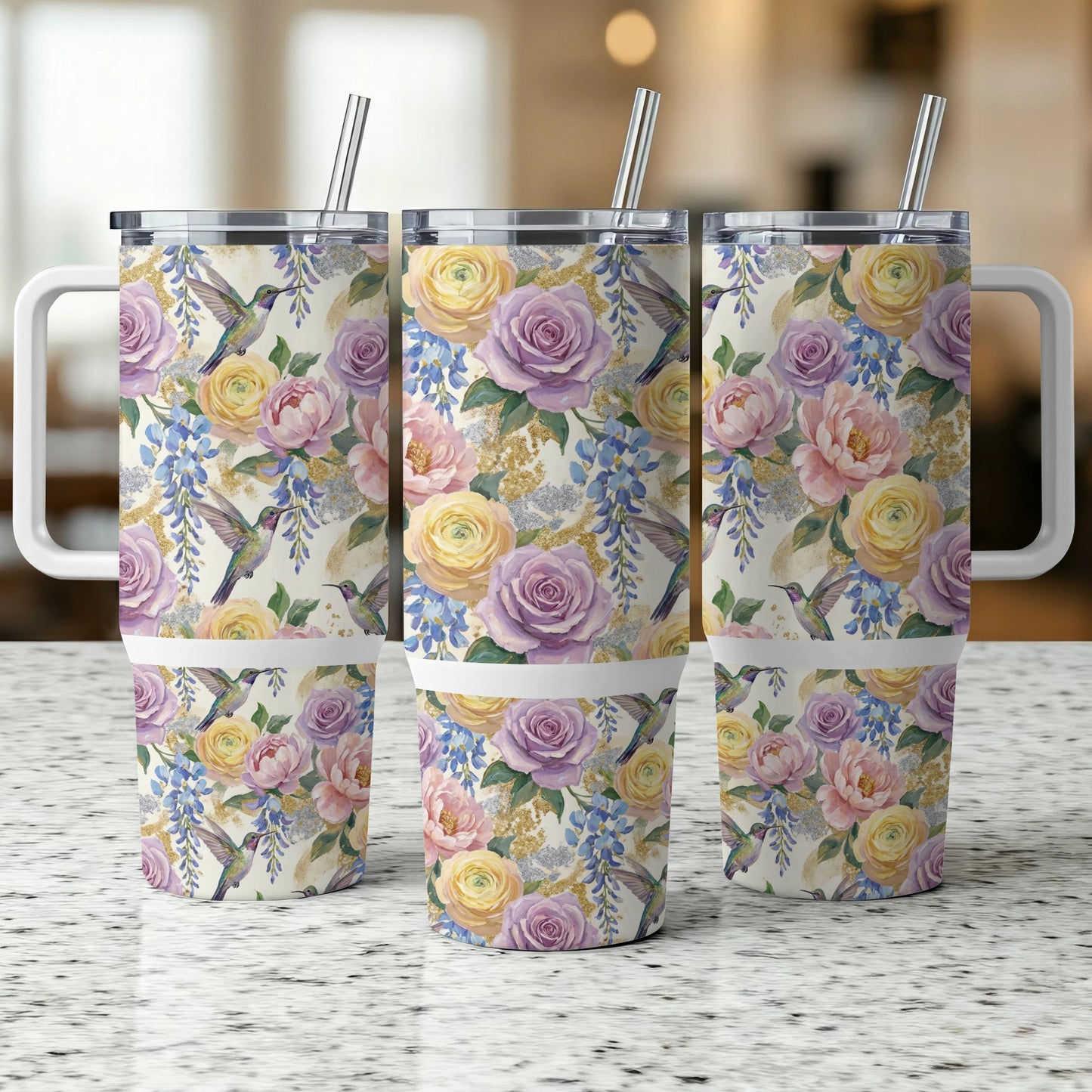 Floral hummingbird pattern on three stainless steel travel tumblers with lids and straws.