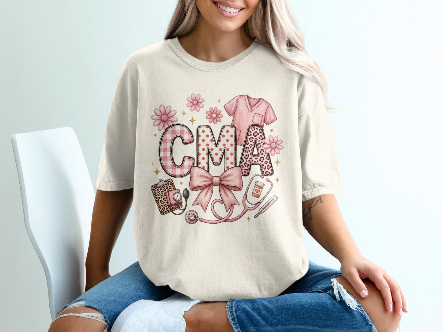 Cream t-shirt with "CMA" in pink plaid and leopard print, stethoscope, bow, and medical scrubs.