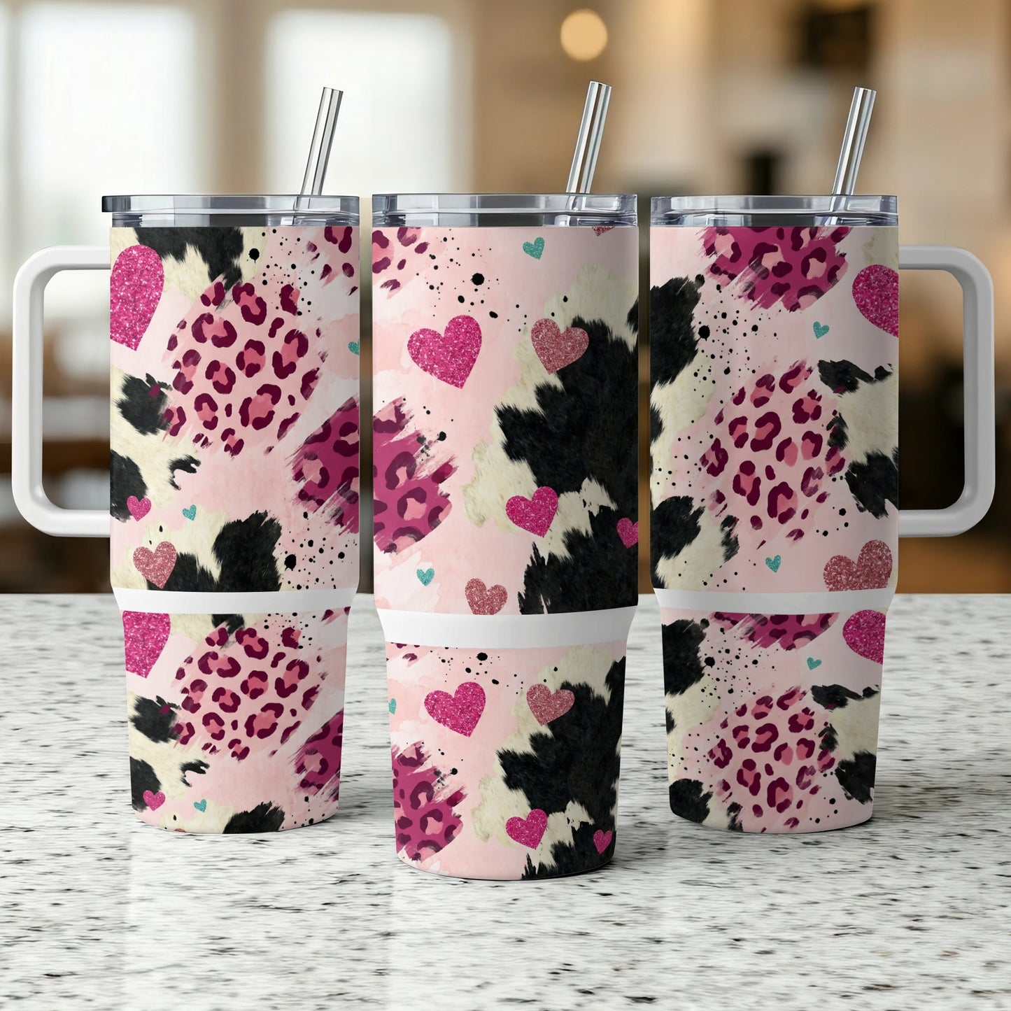 Three pink, leopard print, and cow print tumblers with hearts and straws.