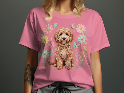 Pink t-shirt with a fluffy dog wearing a collar surrounded by flowers and butterflies.