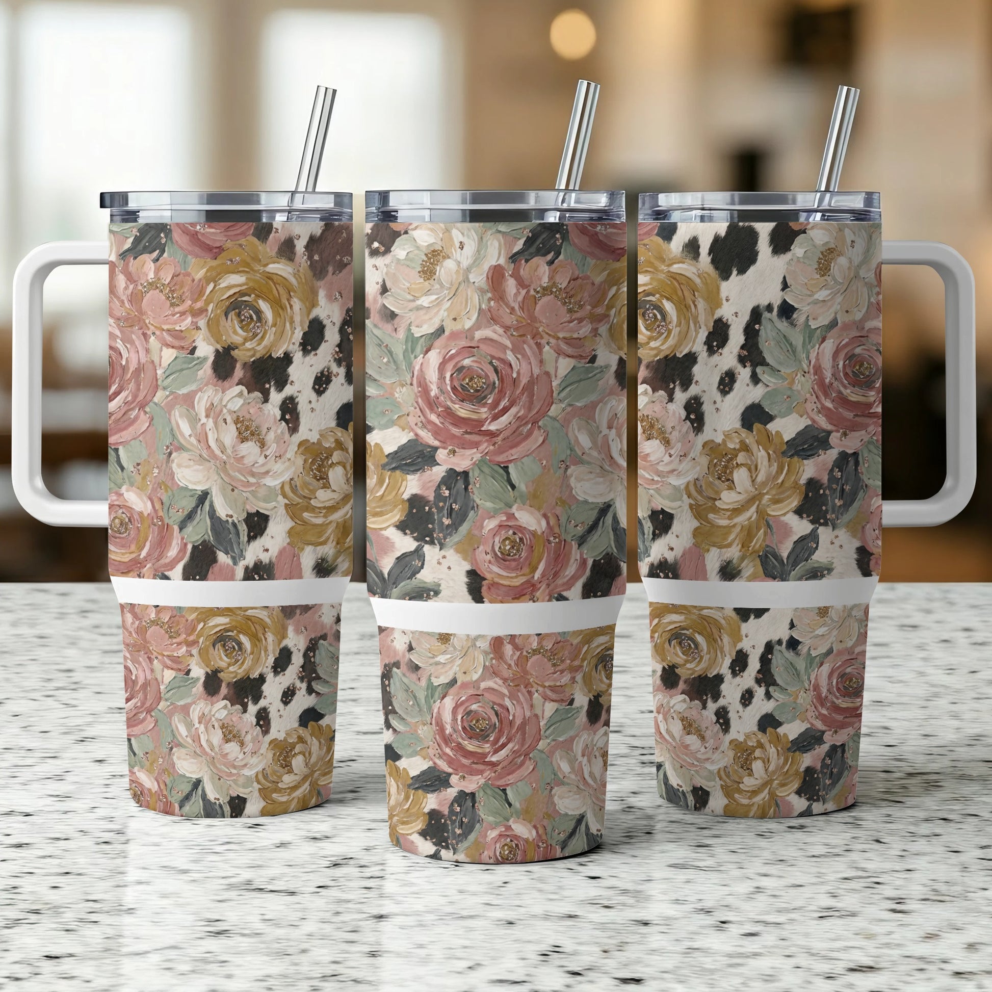Three tumblers with floral and cow print designs, featuring handles and straws.